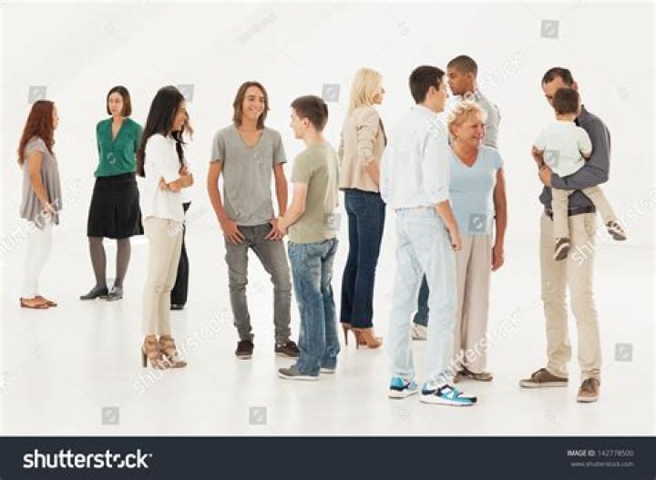 a group of people standing next to each other in front of a wall with