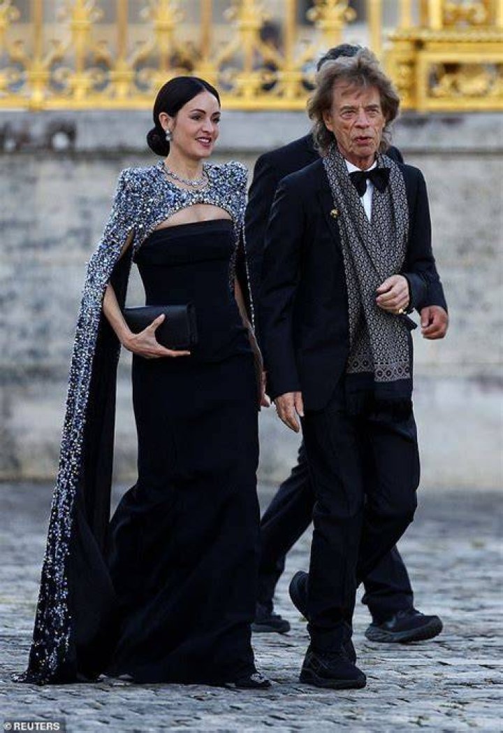 Sir Mick Jagger, 80, battles strong winds as he arrives at King Charles